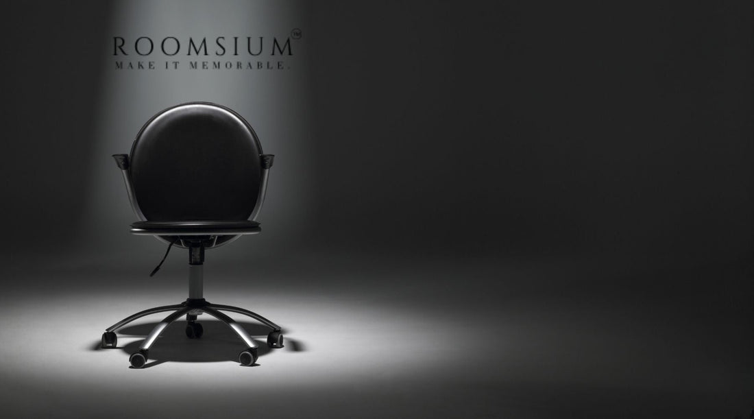 A minimalist image of an empty black office chair placed in a spotlight
