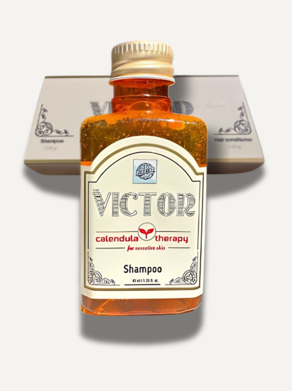Close-up of Roomsium Victor Shampoo bottle in front of amenities box on light background