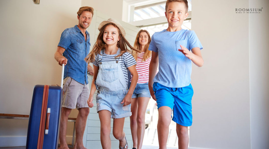 A family of four joyfully walking into a vacation rental. The father is holding a suitcase, and the children, along with the mother, are smiling and excited as they enter the bright, welcoming space.