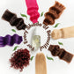 Collection of hair extensions in various colors with a bottle in the center on a white background.